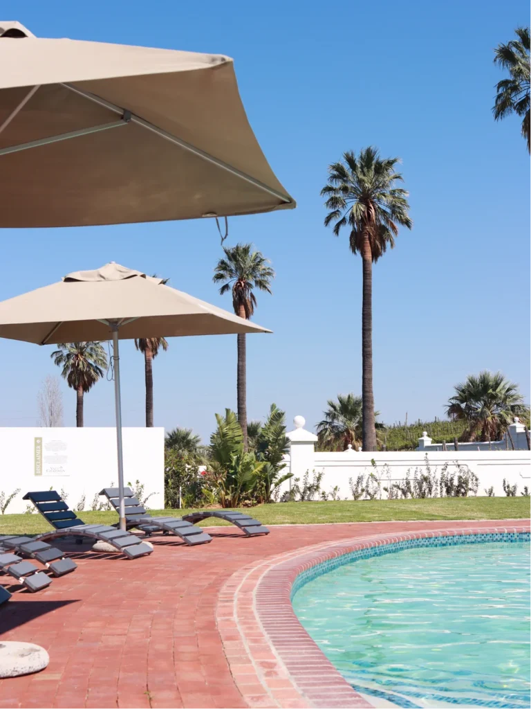 swimming pool with palms and umbrellas at Val Du Charron family friendly hotel